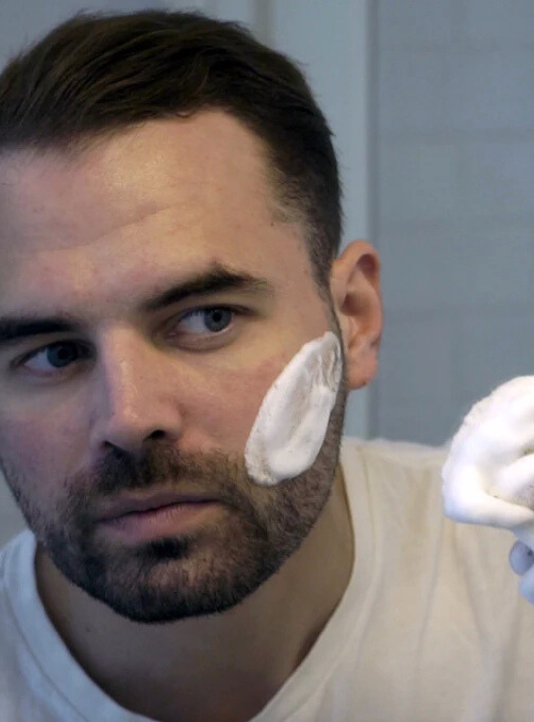 Image of man applying shave cream with a Professional Shave Brush in the bathroom mirror