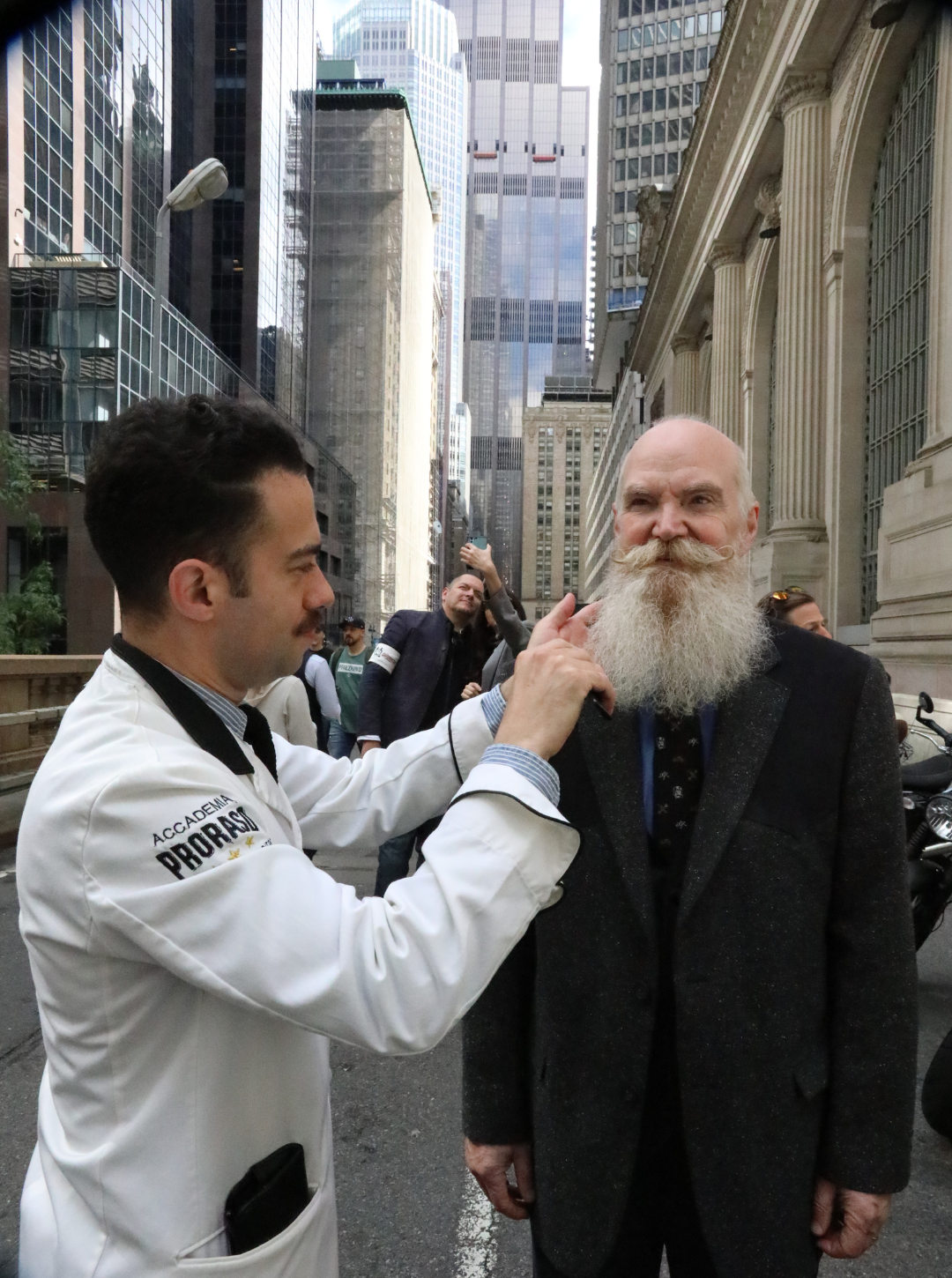 Image of man with large beard and moustache getting styled by a Proraso Master Barber at the entrance to Grand Central Station