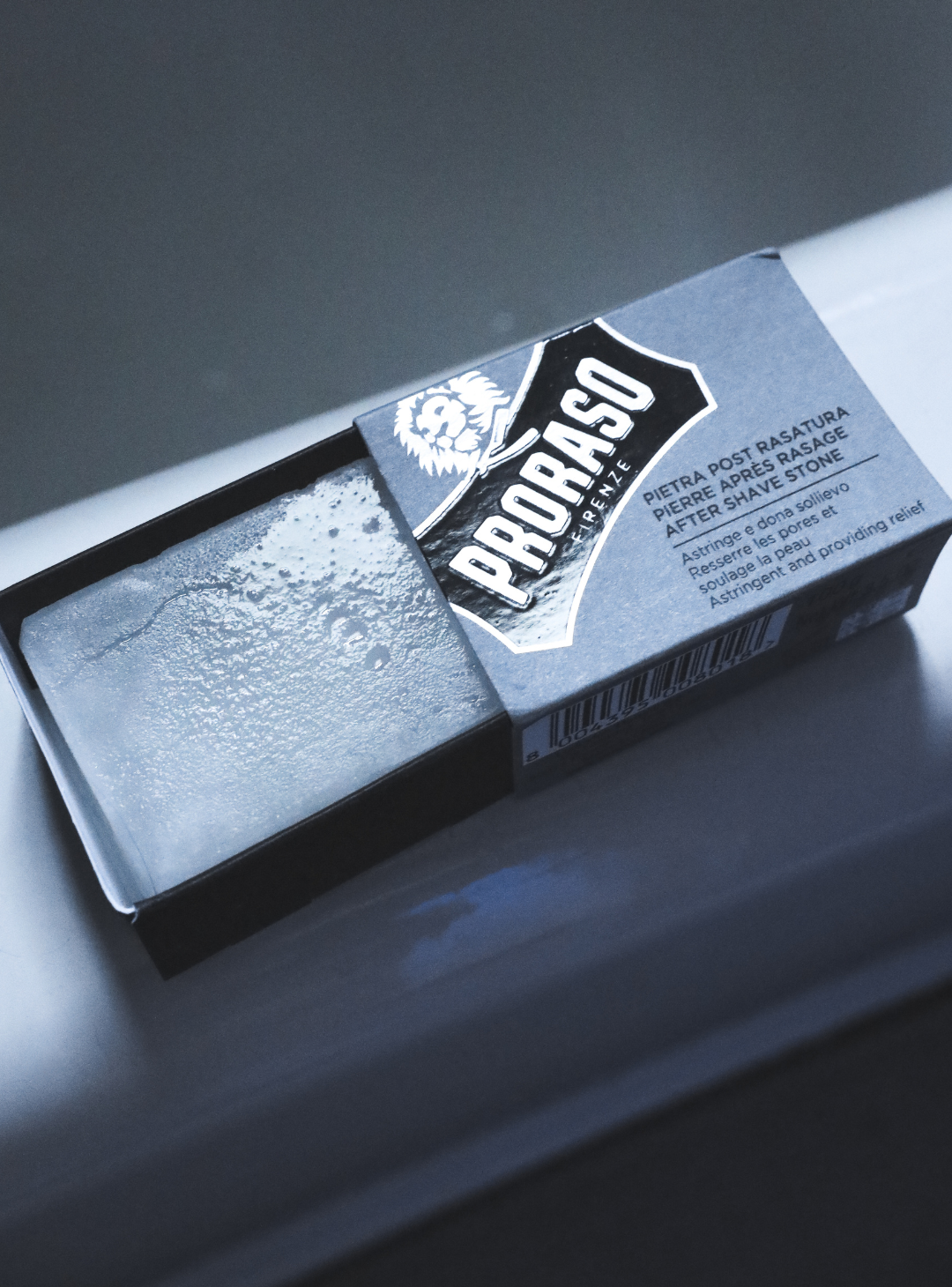 Post-Shave Stone open in packaging sitting on the side of bathtub