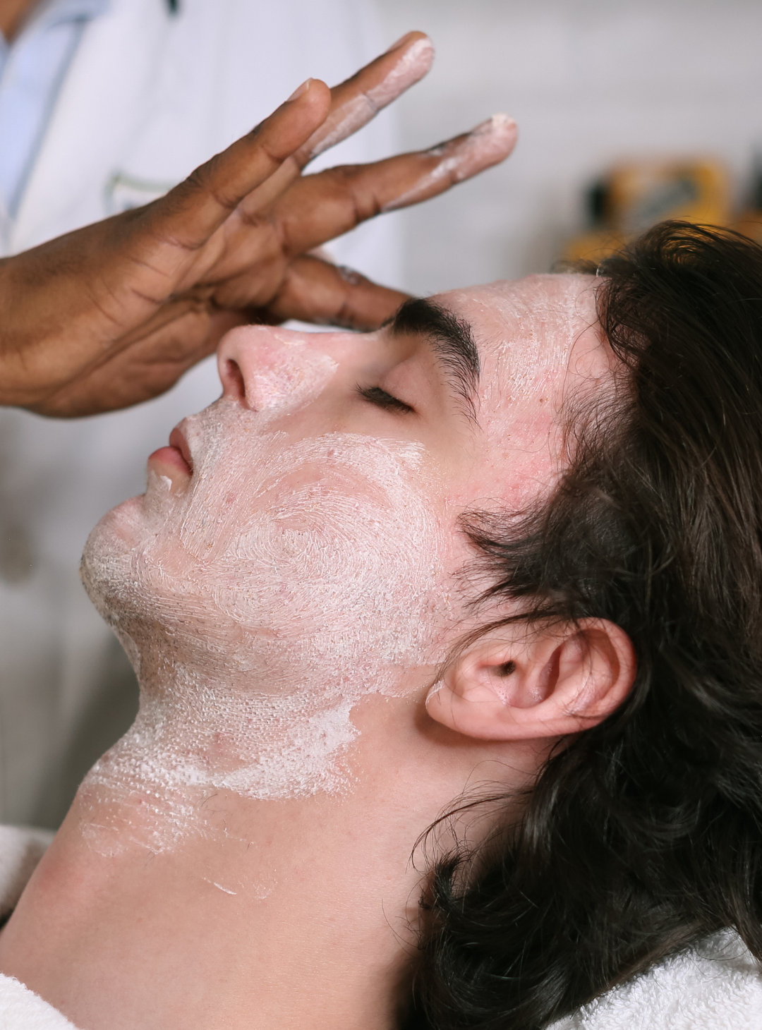 Barber applying Exfoliating Beard Paste & Facial Scrub to a clients skin