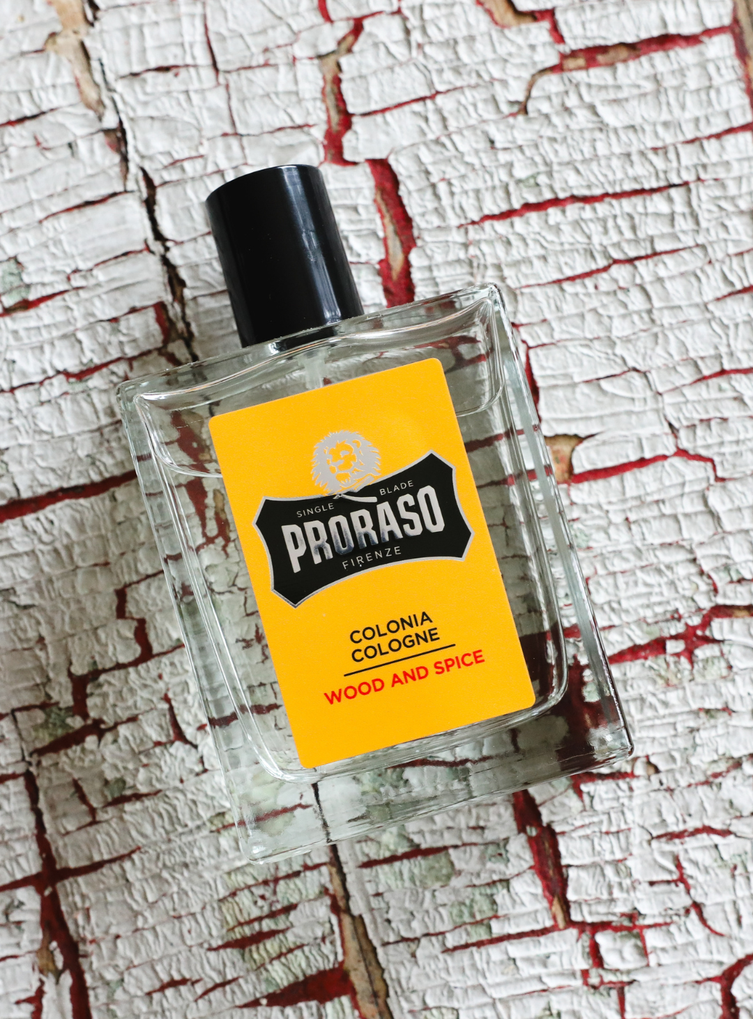 Bottle of Wood & Spice Cologne sitting on a wood background