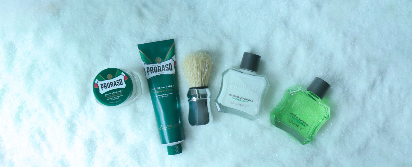 Refresh Formula lineup Pre-Shave Cram, Shave Cream Tube, Professional Shave Brush, After Shave Balm and After Shave Lotion laying in the snow