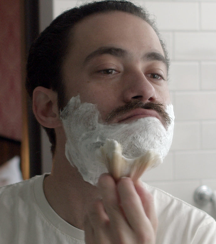 Proraso Professional Shaving Brush being used to apply shaving cream to a man's face.