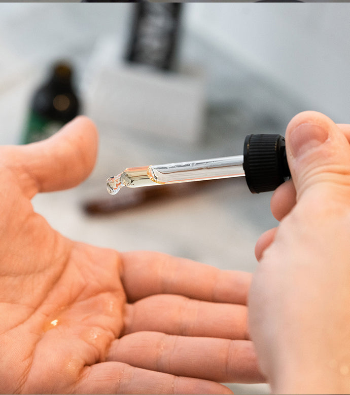 Proraso Azur Lime Beard Oil being dropped onto the balm of a hand. Just a couple of drops will do to nourish and moisturize your beard.