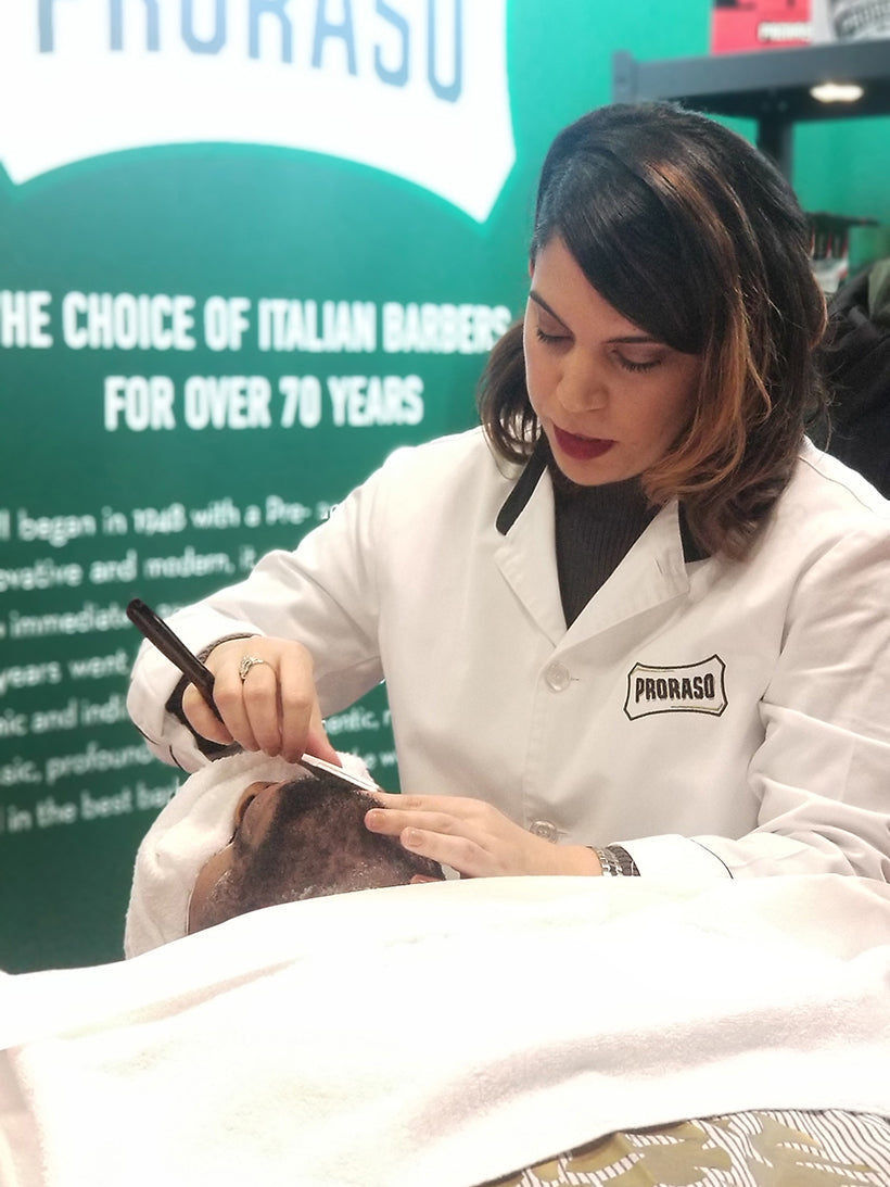 Woman shaving man's beard at International Beauty Show