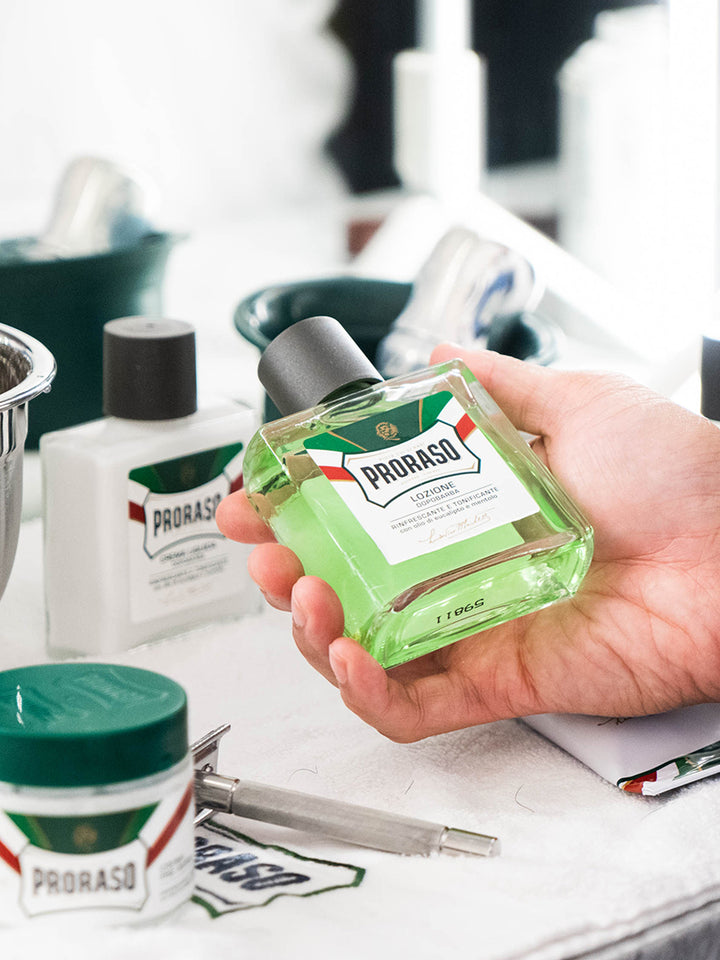 Hand holding Proraso After Shave Balm Refresh formula
