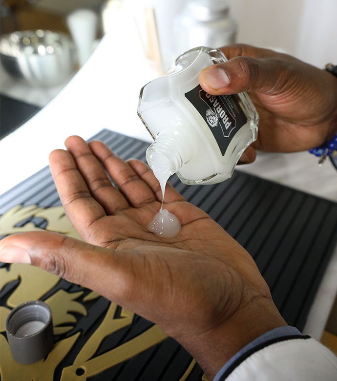 Bottle of Beard Balm being poured into hand at a barber counter