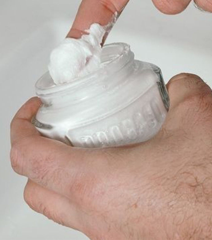 Sensitive Pre-Shave Cream being scooped out of a jar closeup 