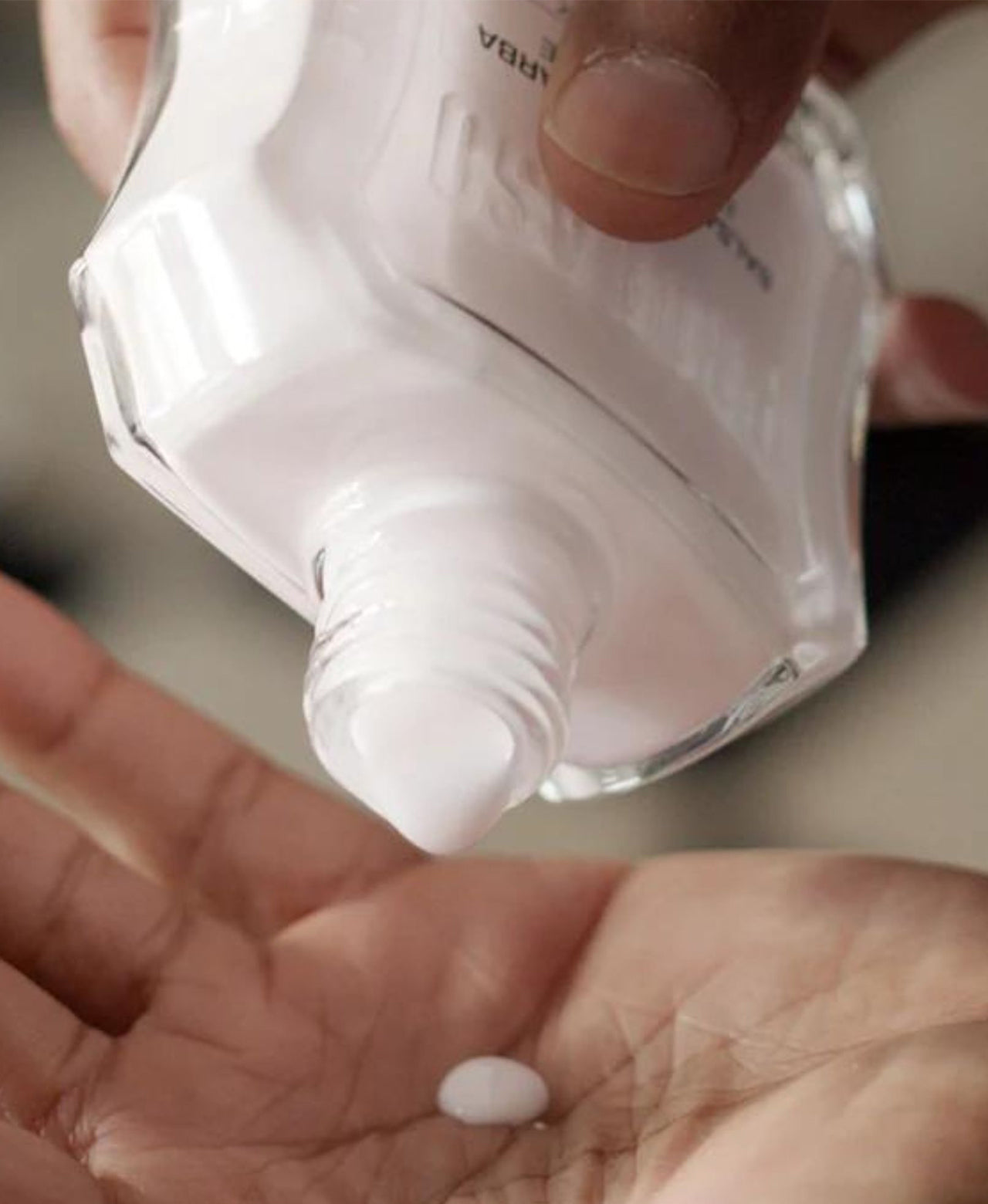 Bottle of Nourishing After Shave Balm being poured onto hand of man