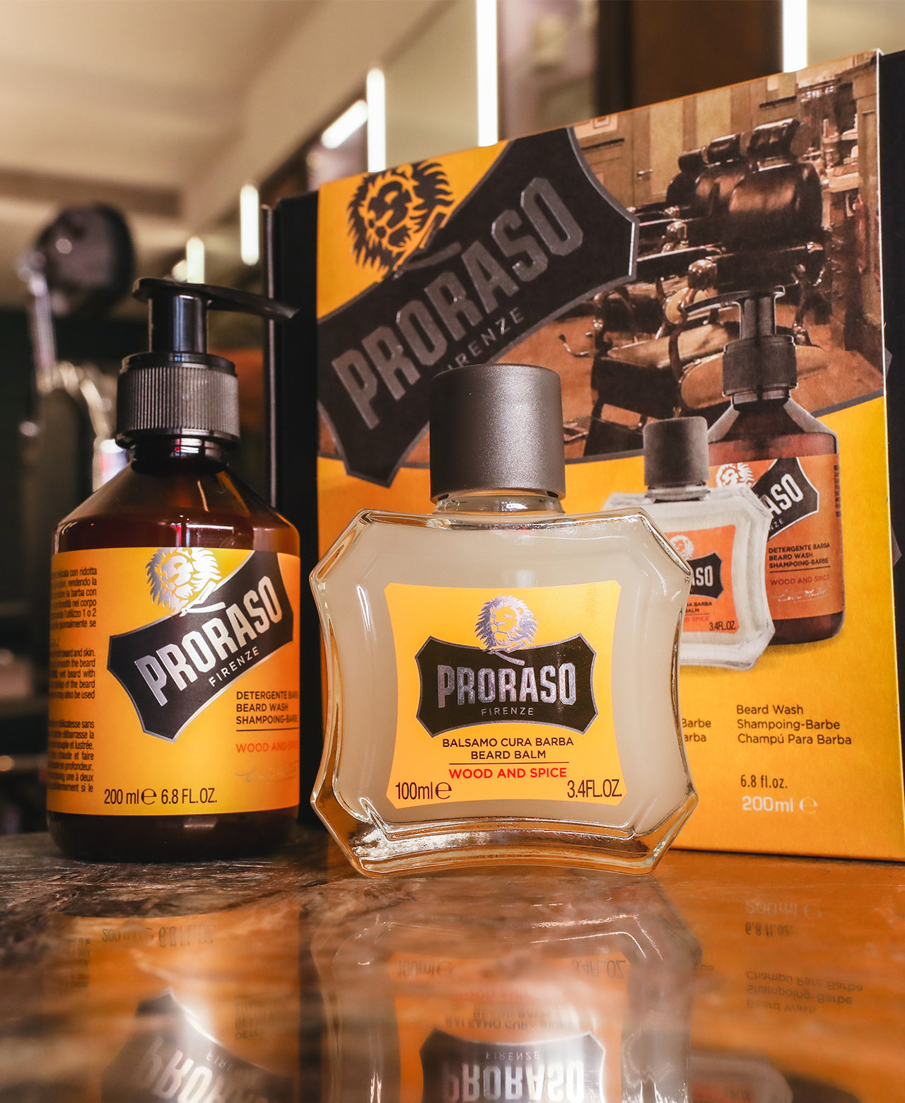 Wood & Spice Classic Beard Box with components in front of it: Beard Wash and Beard Balm sitting on dark marble table with barbershop in background