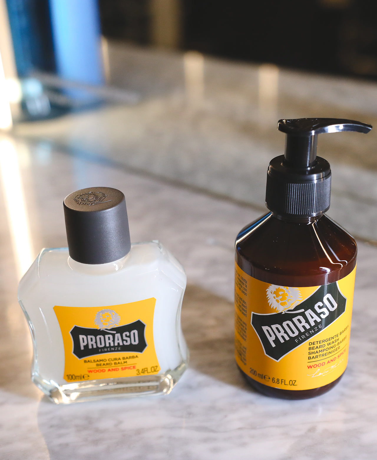 Wood & Spice Beard Balm and Beard Wash sitting on barbershop counter with mirror in background 