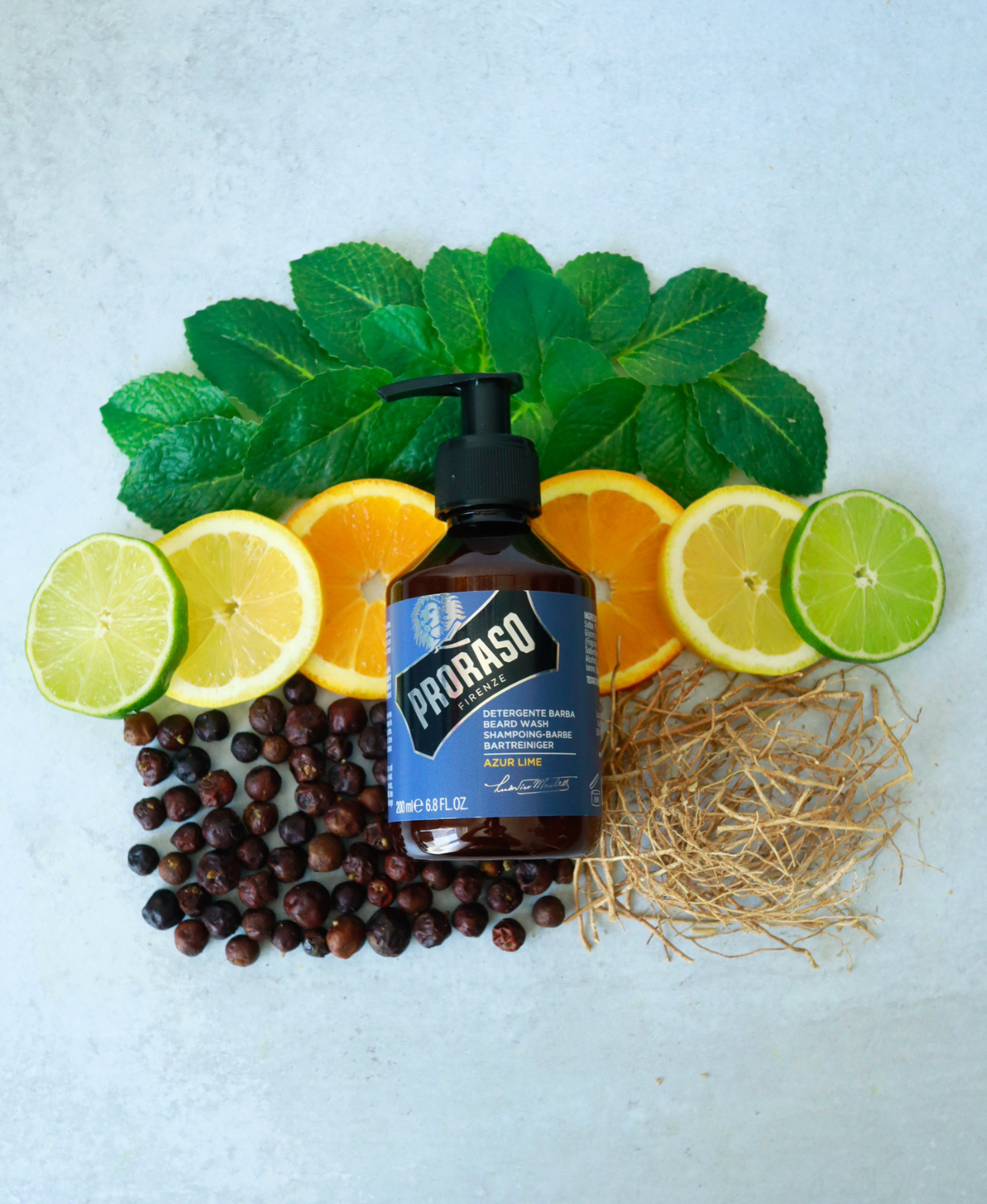 Beard Wash in Azur Lime Fragrance laying on top of fragrance notes: Patchouli, Citrus, Juniper Berries and Moss.