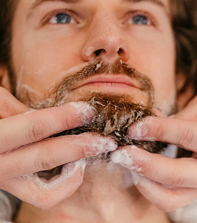 Man getting his beard washed by a barber 