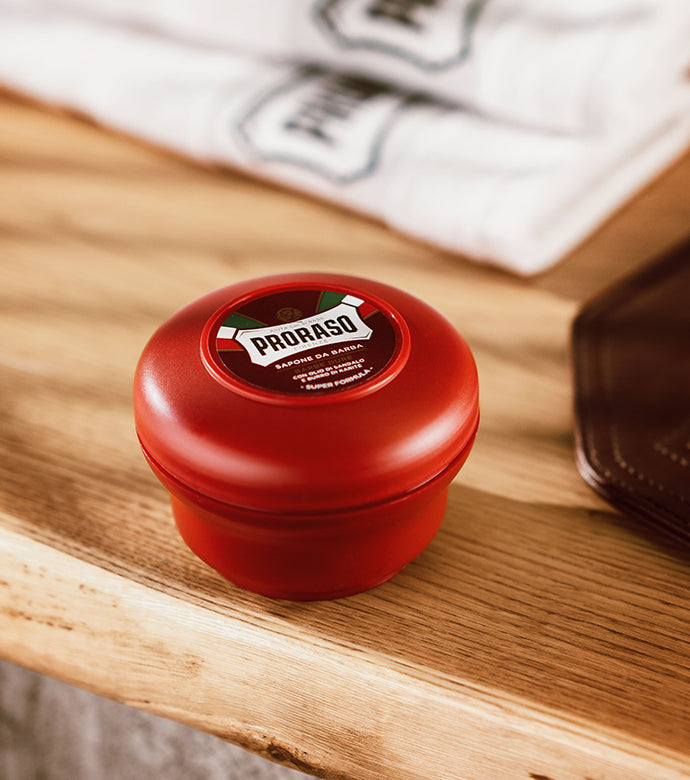 Nourishing Shave Soap in a Bowl sitting on a light wood table with Proraso white towels in background