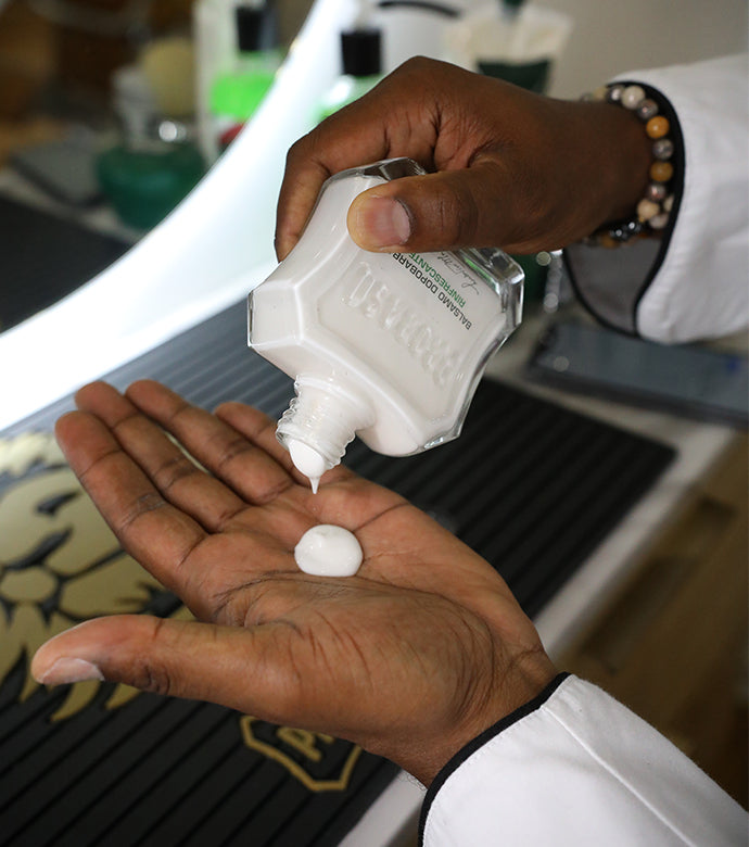 Jar of Refreshing After Shave Lotion being poured into palm of hand