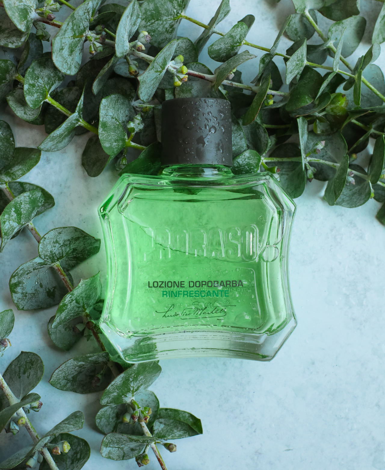 Refreshing After Shave Lotion bottle with eucalyptus leaves on a grey table