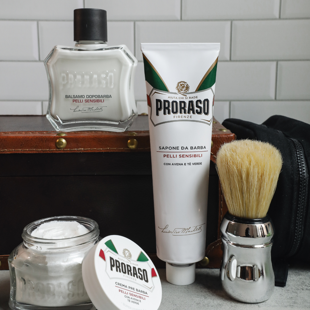 Full Proraso Sensitive lineup in front of a white tile background. Including Sensitivec Pre-Shave Cream, Shave Cream Tube, After Shave Balm, and Professional Shaving Brush