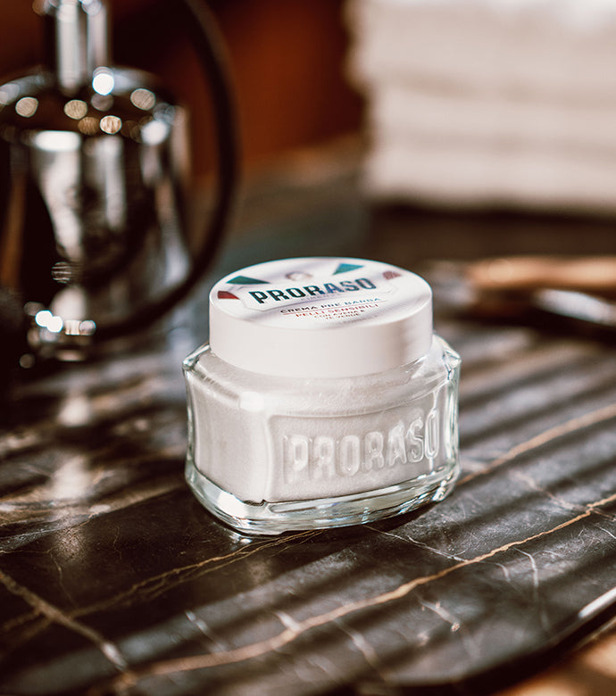 Sensitive Pre-Shave Cream jar sitting on dark marble table with silver spray bottle in background 