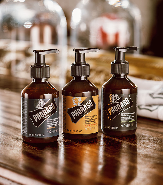 Left to right Azur Lime, Wood & Spice and Cypress & Vetyver Beard Washes sitting on a brown wooden table