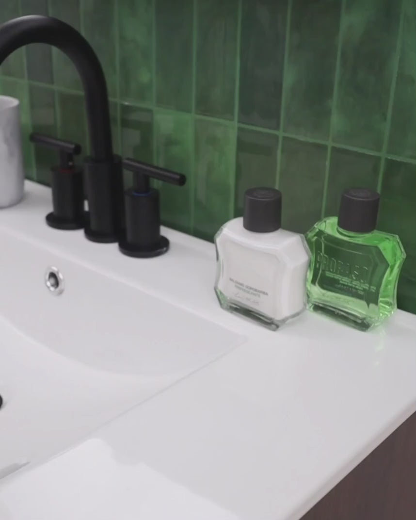 After Shave Balm Refreshing for All Skin Types and After Shave Lotion  Refreshing for All Skin types on back of sink- man applies After Shave Balm to skin