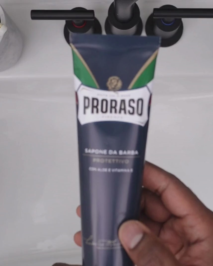 Man building a thick lather with Shave Cream Tube Protective for Dry Skin and a Professional Shave Brush in a bathroom