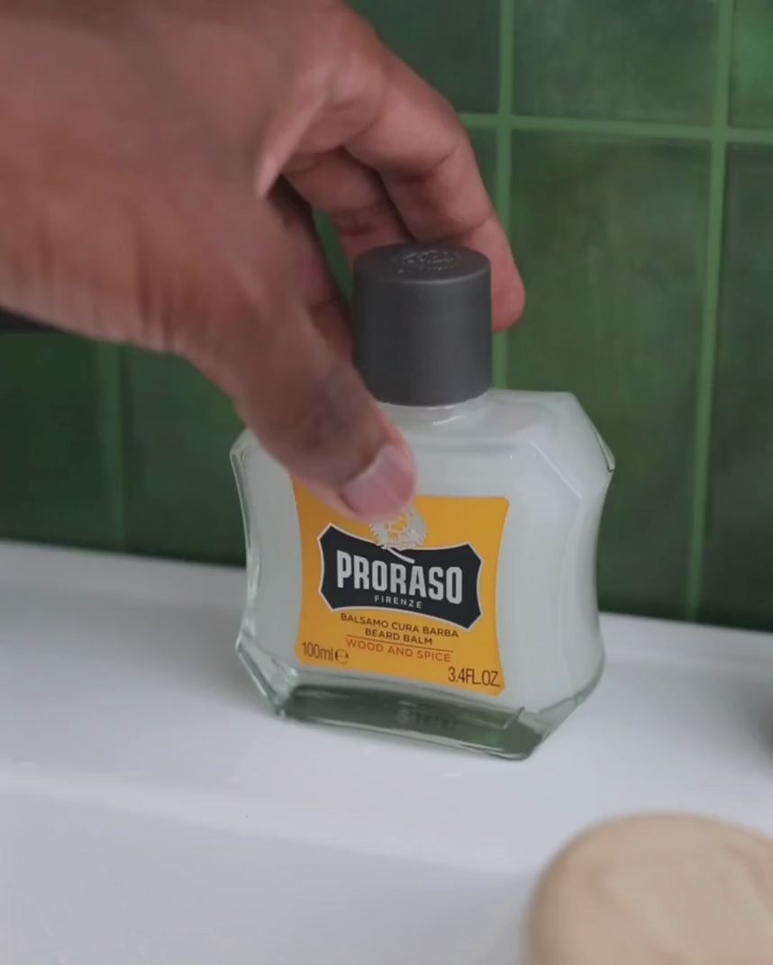 Man pouring and applying Beard Balm in Wood & Spice Fragrance in bathroom