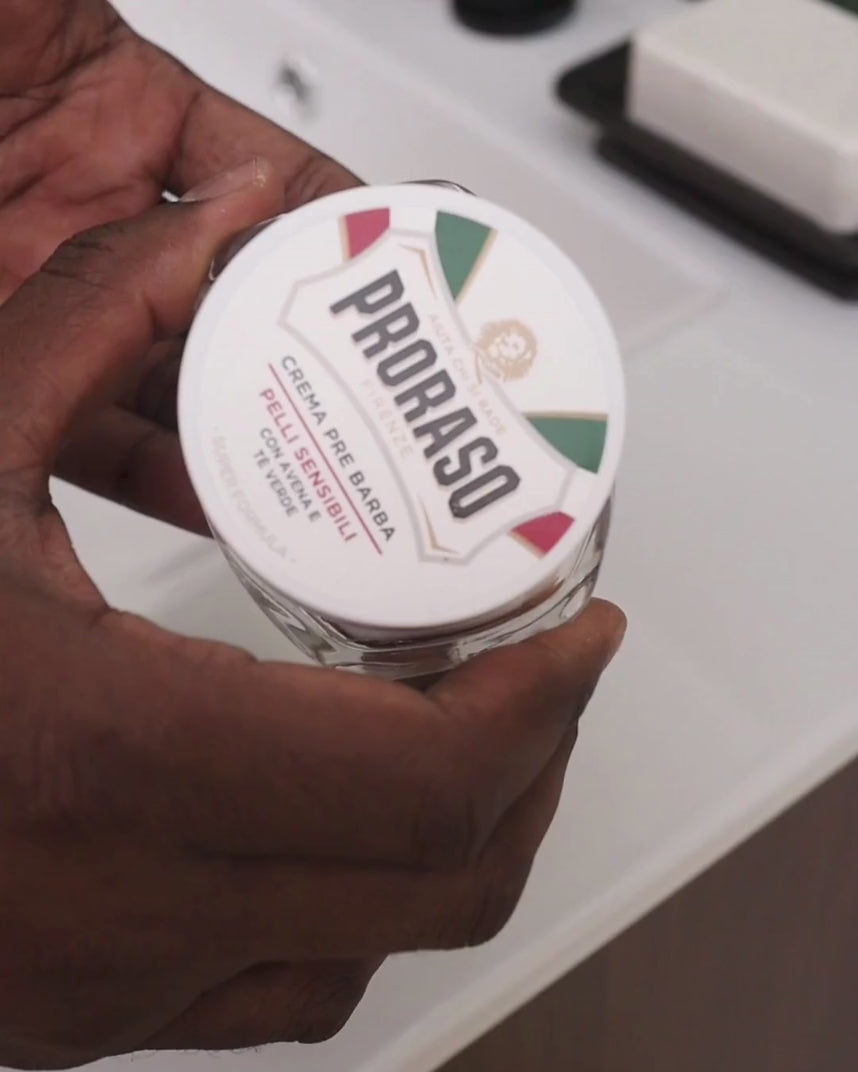 Man opening jar of Pre-Shave Cream for Sensitive Skin and scooping out enough to apply 