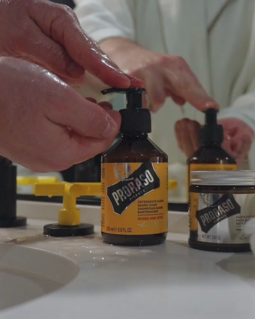 Man using Beard Wash in Wood & Spice Fragrance to his thick beard in a bathroom