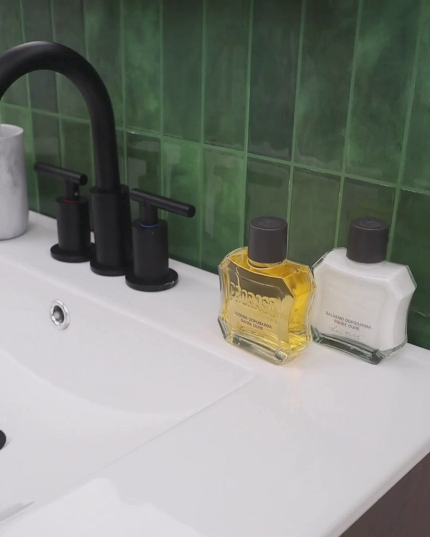 Man pouring a few slashes of After Shave Lotion For Coarse Beards and applying to face in a bathroom
