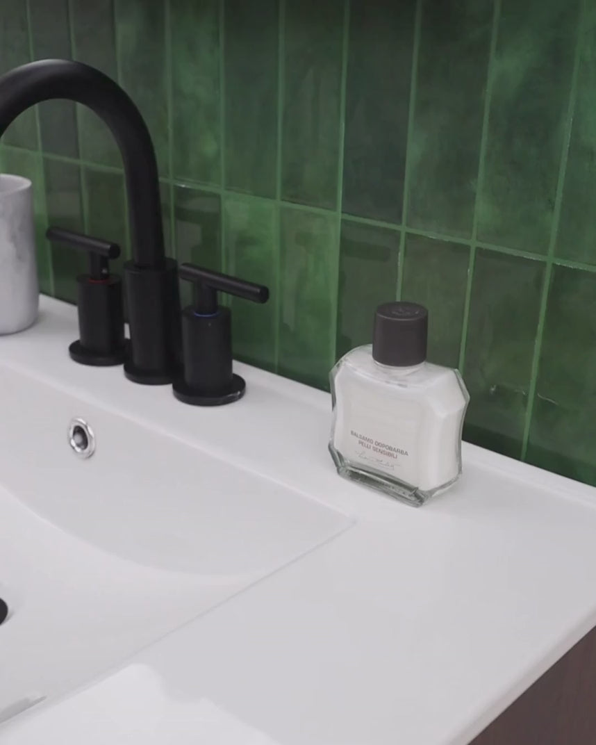 Man applying After Shave Balm for Sensitive Skin at bathroom sink.