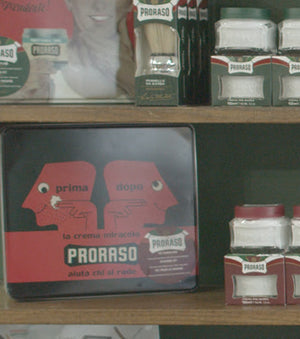 Proraso Vintage Prima Dopo Tin - Nourishing for Coarse Beards - Shave Cream Tube, After Shave Lotion, Pre-Shave Cream on a barber shop shelf. 