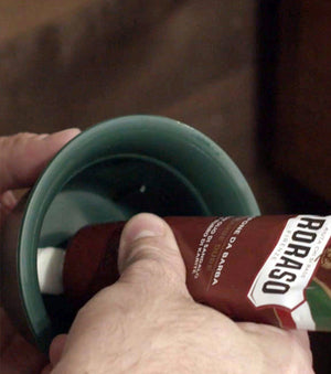 Proraso Nourishing for Coarse Beards Shave Cream Tube being squeezed into a shave cream mug to build a thick lather.