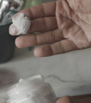 Proraso Protective Pre-Shave Cream being scooped of our jar before being applied to the face.
