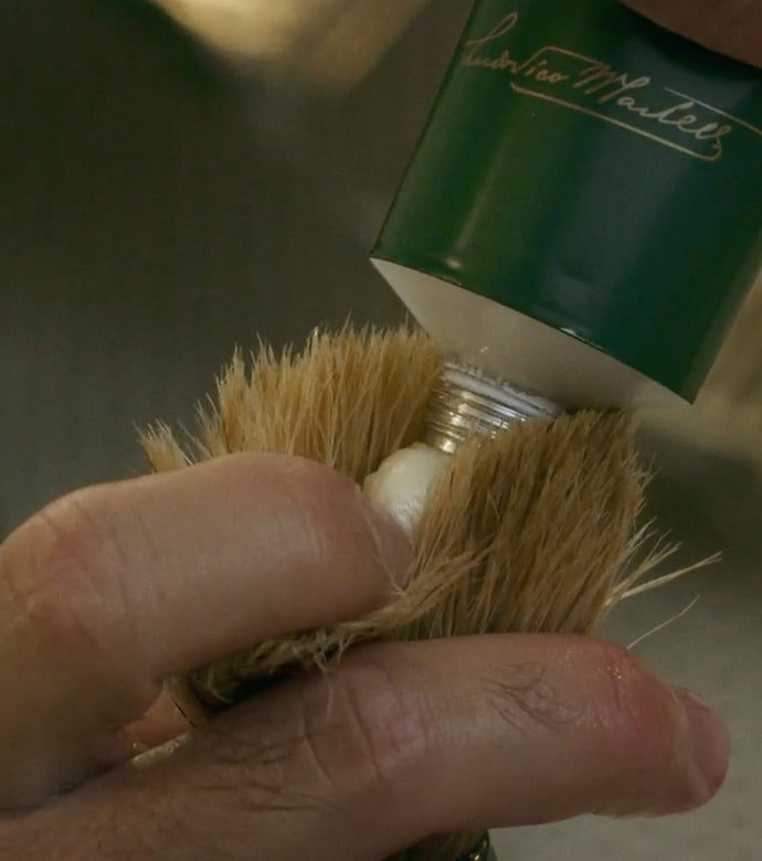Proraso Refresh Shaving Cream Tube being squeezed into the bristles of a Proraso Professional Shaving Brush.