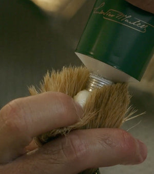 Proraso Refreshing Shaving Cream Tube being squeezed into Proraso Professional Shaving Brush to create a thick lather.