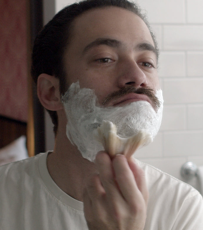 Proraso Sensitive Shaving Cream Tube being applied to lower half of face with a Proraso Professional Shaving Brush.