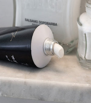 Proraso Protective Shave Cream Tube laying on counter with a small amount of Shave Cream squeezed out of tube.  Protective After Shave Balm and Protective Pre-Shave Cream in background.