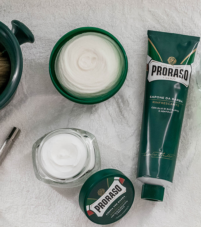 Proraso Refreshing Shaving Soap in a Bowl on the counter with Proraso Refreshing Pre-Shave Cream, Proraso Refreshing Shave Cream tube and shave mug with Proraso Professional Shave Brush.