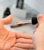 Proraso Cypress & Vetyver Beard Oil being dropped into palm of hand.