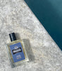 Proraso Azur Lime Cologne sitting on the edge of a swimming pool.