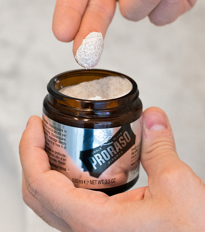 Exfoliating Beard Paste and Facial Scrub being scooped out of jar showing texture.