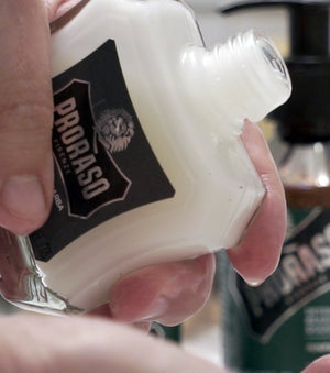 Refresh Beard Balm bottle in hand close up being poured.