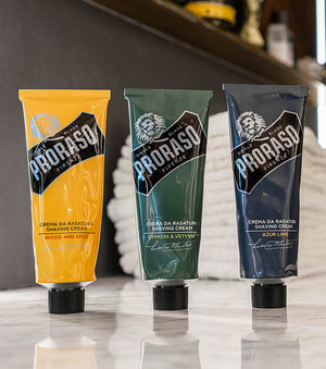 Proraso Single Blade Shave Cream Tube in all three fragrances Wood and Spice, Cypress & Vetyver and Azur Lime on the counter of a barber shop.
