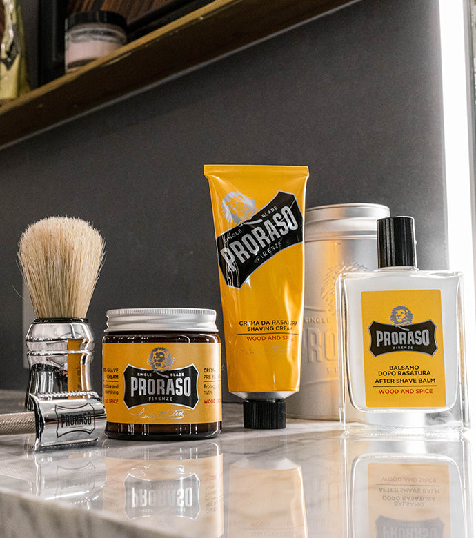 Custom Proraso razor, Professional Shaving Brush and Proraso Single Blade Collection Pre-Shave Cream, Shave Cream in a Tube and After Shave Balm on the counter of a barber shop.