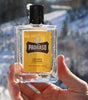 Proraso Wood & Spice Cologne being held in hand in the mountains.